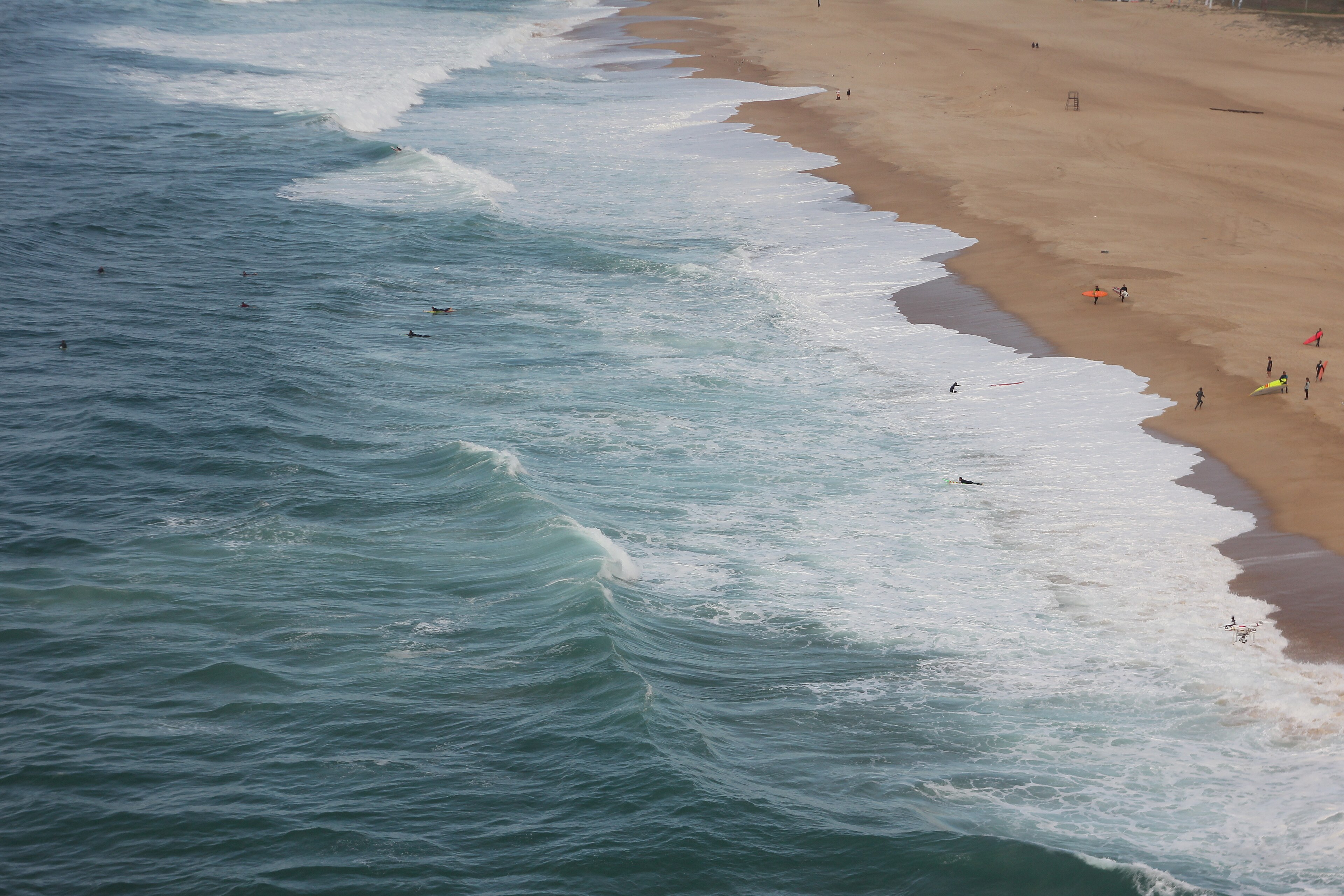 Nazaré shoreline with surfers — aerial view