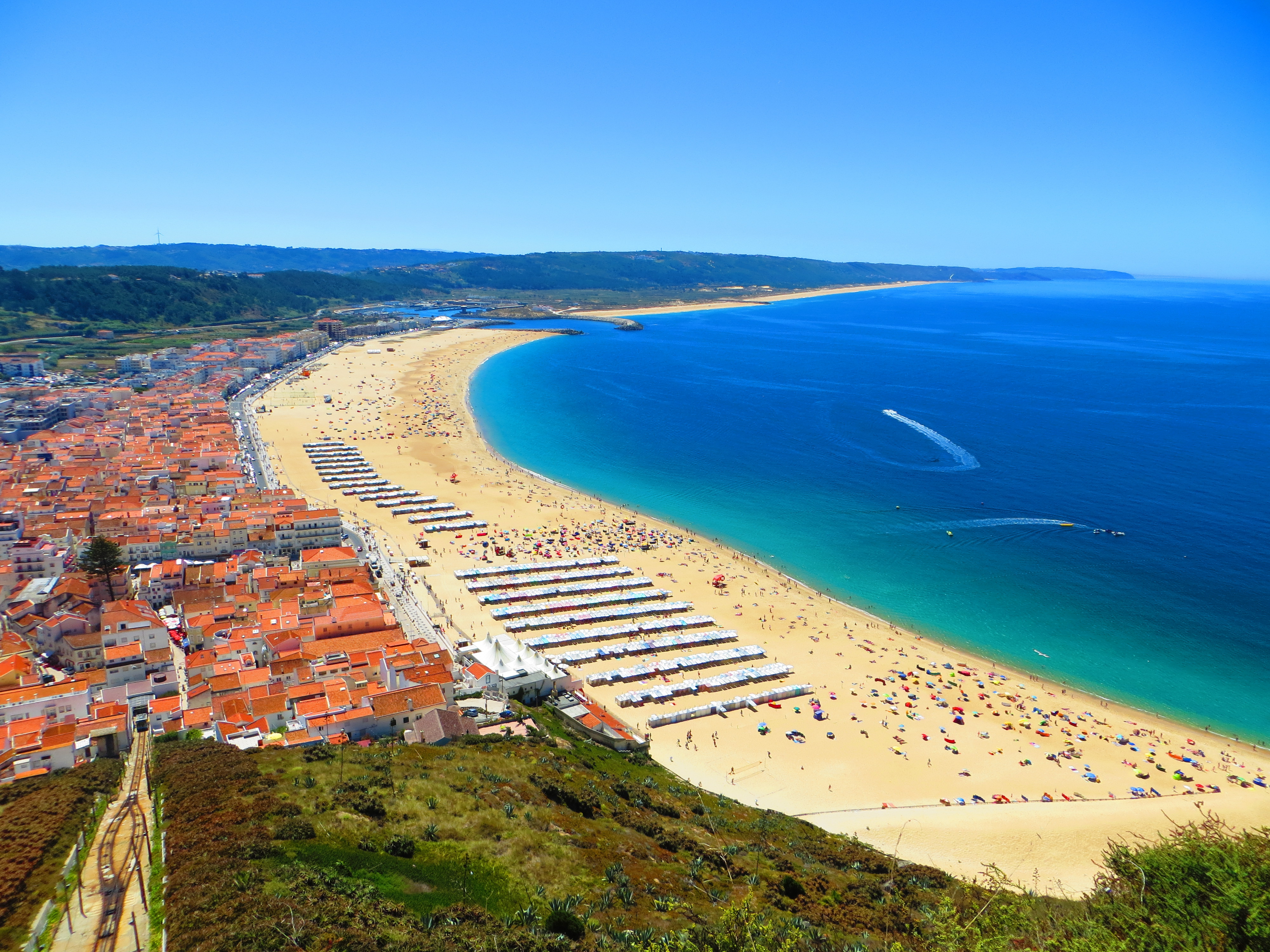 Praia da Nazaré (village beach) from the Sítio headland, with summer striped tents